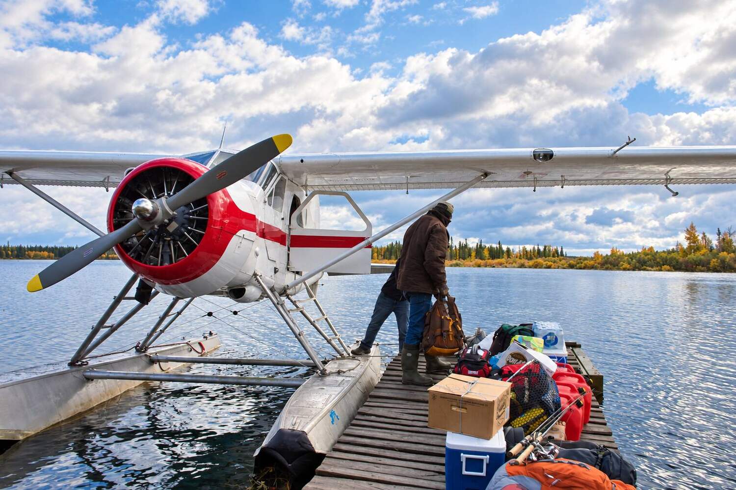 Silver floatplane at an autumn lake dock
